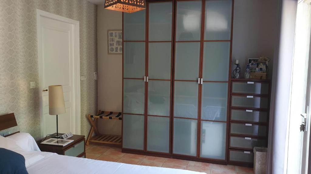 a bedroom with a large glass closet with a bed at La Villa d&#39;Olivène in Cuers