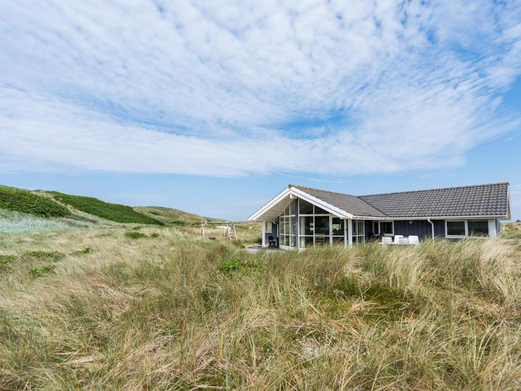 une maison sur la plage avec de l'herbe haute dans l'établissement Holiday home Hvide Sande LVIII, à Hvide Sande
