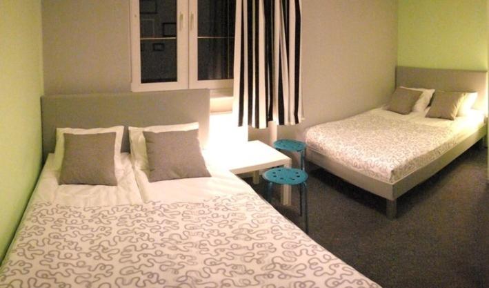 a bedroom with two beds and a window at Olive Hostel in Gdańsk