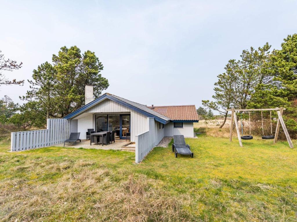 une petite maison sur une colline avec une balançoire dans l'établissement Holiday home Blåvand CLXXIV, à Blåvand