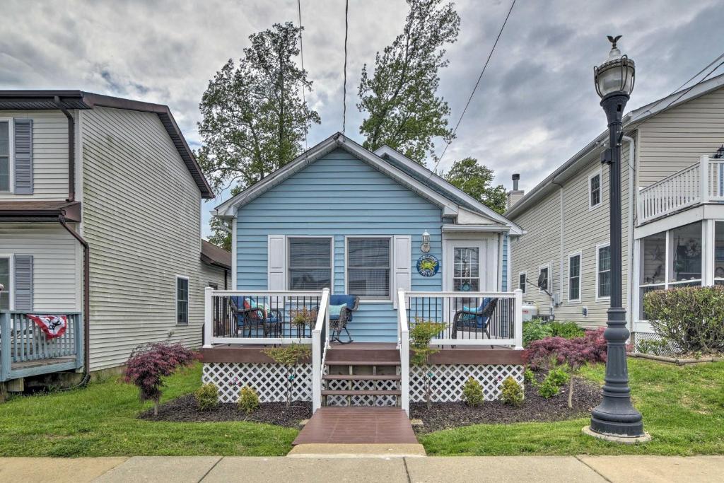 uma casa azul com um alpendre e uma casa em Coastal Pet-Friendly Cottage Less Than half Mi to Beaches em Chesapeake Beach