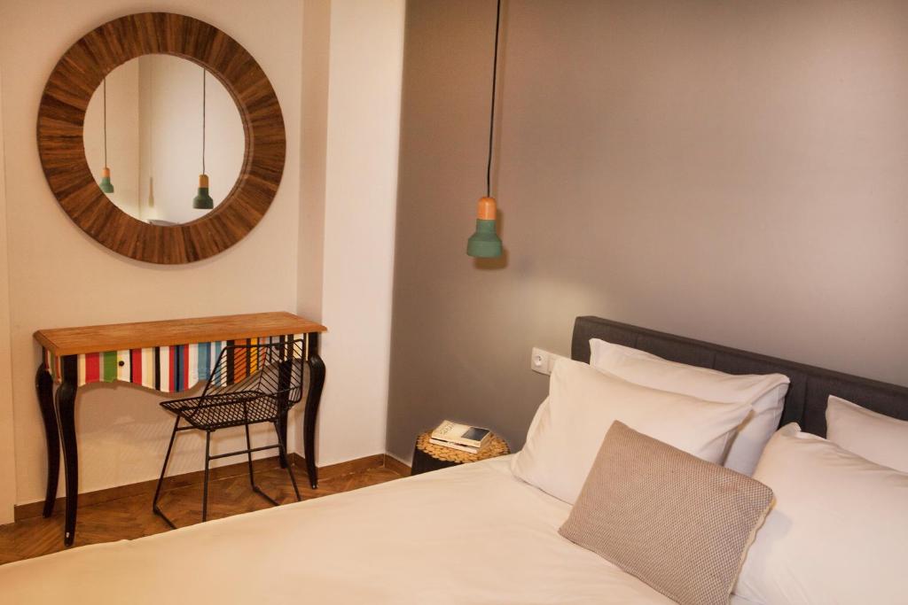 um quarto com uma cama, um espelho e uma cadeira em Central Comfy Modern Flat 2 bedrooms 2 bathrooms em Atenas