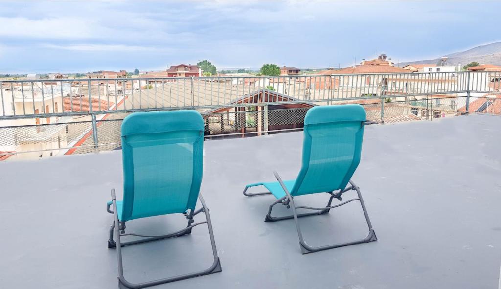 two blue chairs sitting on top of a roof at Studio with city view in Tírnavos