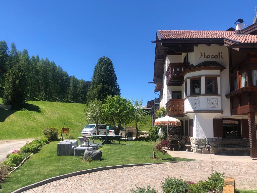 een groot gebouw met een tuin ervoor bij Appartamenti Hacoli in Selva di Val Gardena