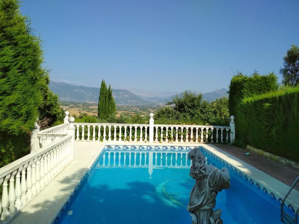 a swimming pool with a white fence and a statue at 4 bedrooms villa with private pool enclosed garden and wifi at Prado del Rey in Prado del Rey