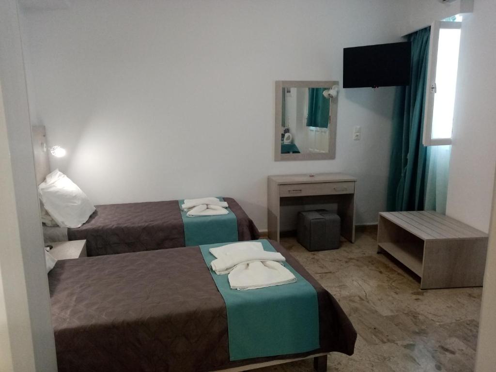 Pokój hotelowy z 2 łóżkami i lustrem w obiekcie Αrgo Studios w mieście Pitagorio