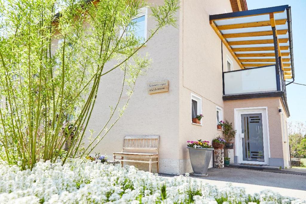 un bâtiment avec un banc devant lui dans l'établissement Ferienwohnungen Wald und Wiese, à Waldkirchen