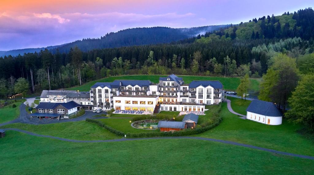an aerial view of a large house on a green field at Hotel Rimberg in Schmallenberg