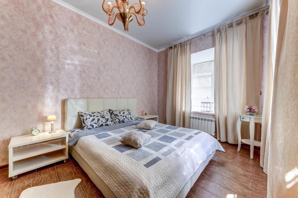 um quarto com uma cama grande e uma janela em Апартаменты Веста на Казанской em São Petersburgo