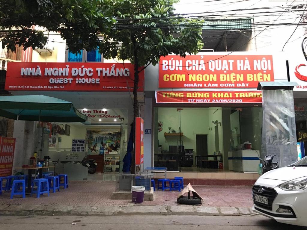 a building with signs on the side of a street at Duc Thang Guest House (Nhà Nghỉ Đức Thắng) in Diện Biên Phủ