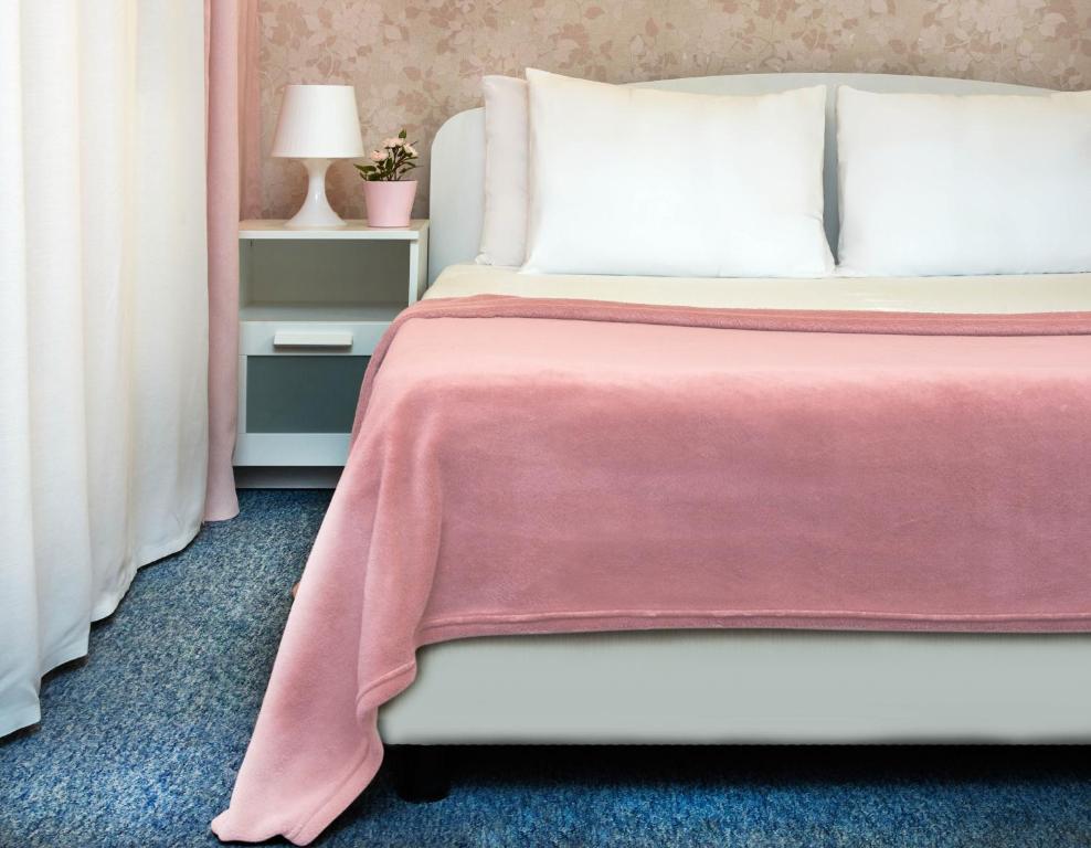 a bedroom with a bed with a pink blanket at Тайм in Moscow