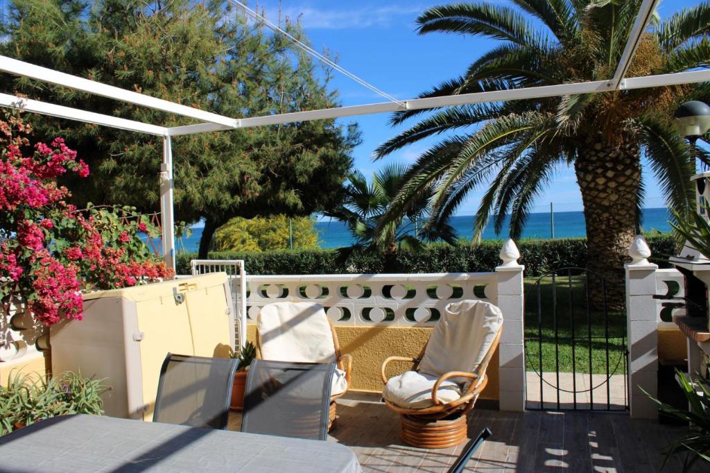 patio con tavolo, sedie e recinzione di Bungalo en primera linea de la playa a El Campello