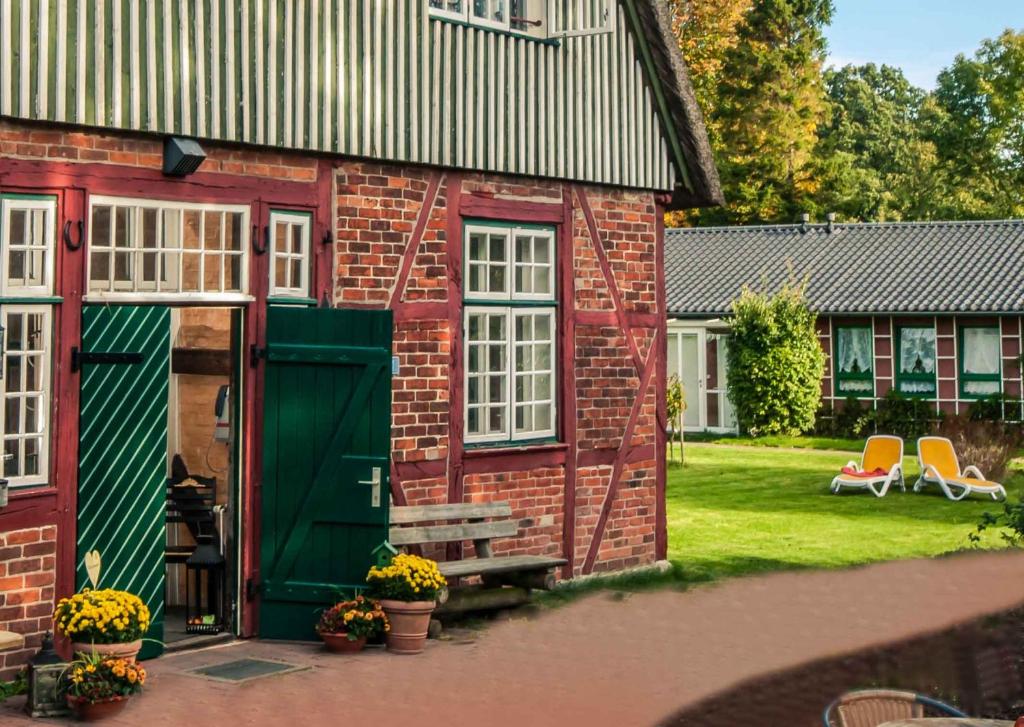 una casa de ladrillo rojo con una puerta verde y un patio en Ferienstätte und Seminarhaus Theodor-Schwartz Travemünde, en Lübeck