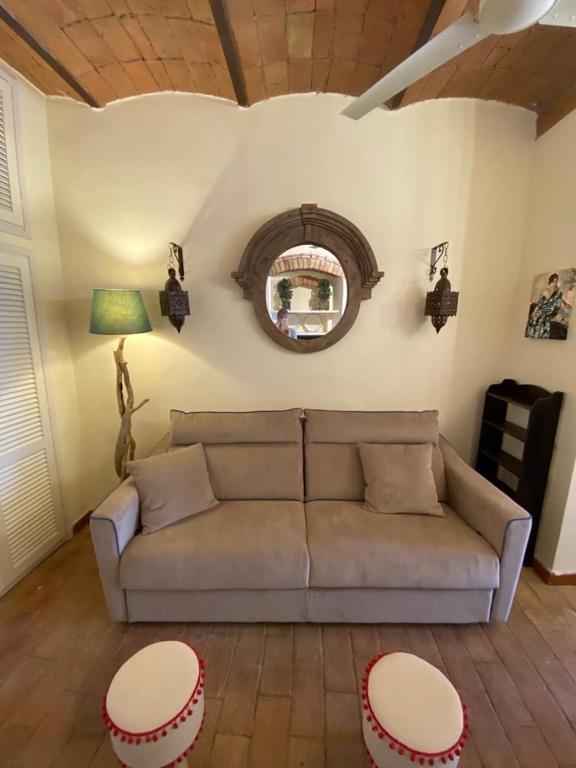 salon z kanapą i lustrem w obiekcie Tuscany Heba w mieście Magliano in Toscana