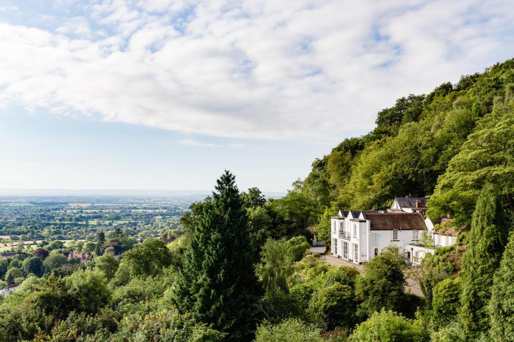 een huis aan de zijkant van een heuvel met bomen bij Cottage In The Wood in Great Malvern