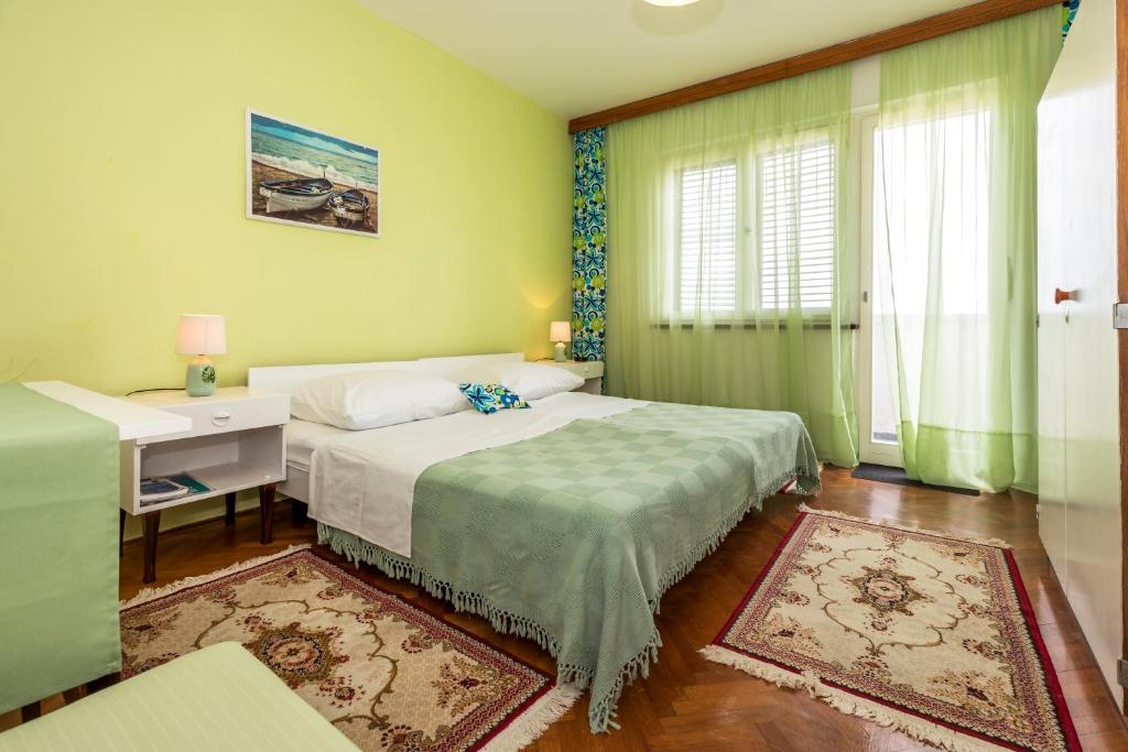 1 dormitorio con 2 camas, escritorio y ventana en Muzic Budget Double Room, en Mali Lošinj
