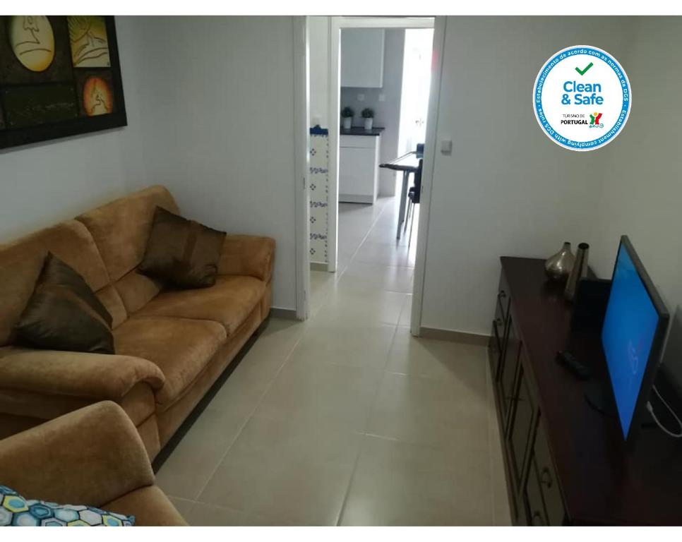 uma sala de estar com um sofá e uma televisão de ecrã plano em Casa da Avó Lucinda na Nazaré