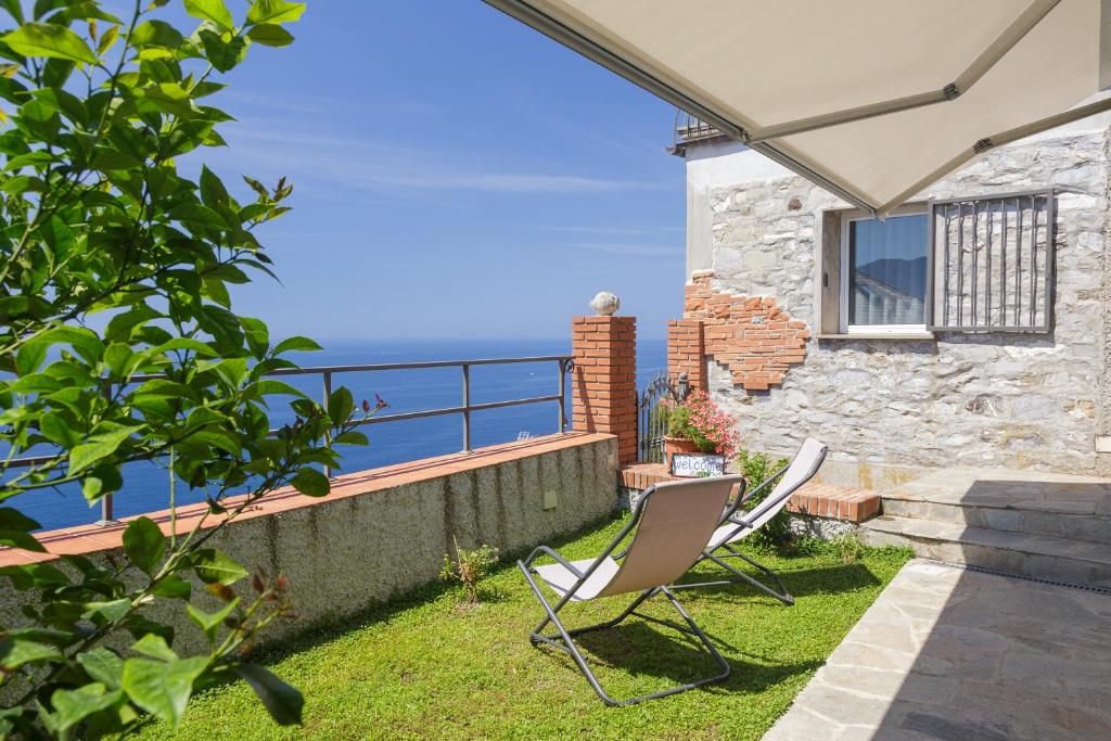 eine Terrasse mit zwei Stühlen und das Meer im Hintergrund in der Unterkunft Polanesi Sea view Home in Sori