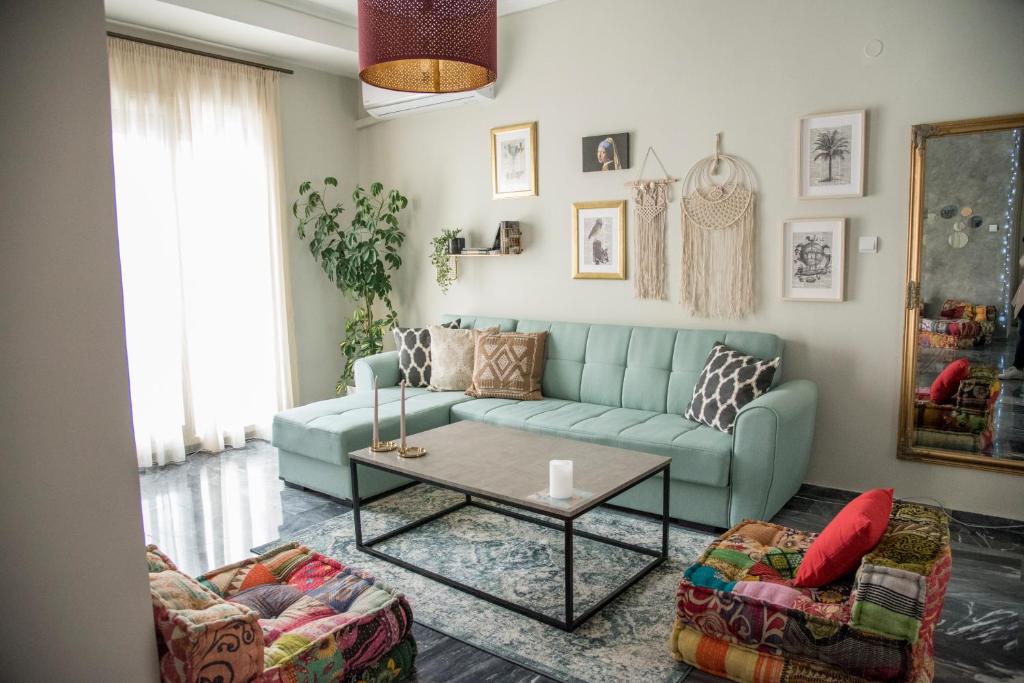 a living room with a blue couch and a table at Be My Guest in Kavala