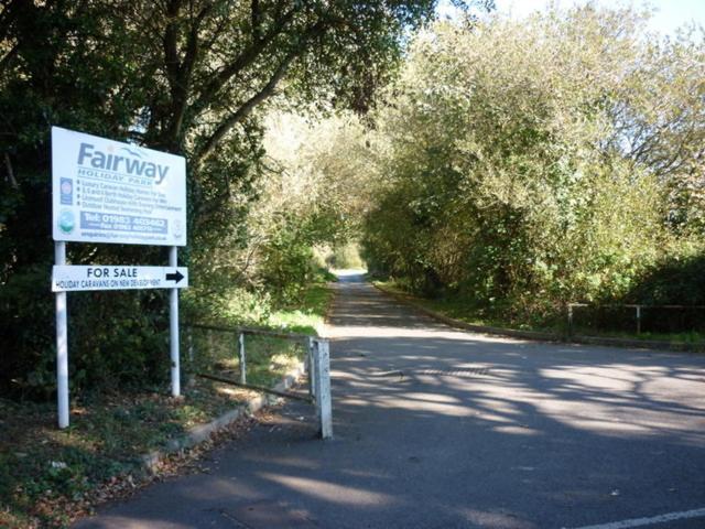 a sign on the side of a road with trees at Sandy Feet Retreat, reduced ferry fair, please contact us direct in Sandown