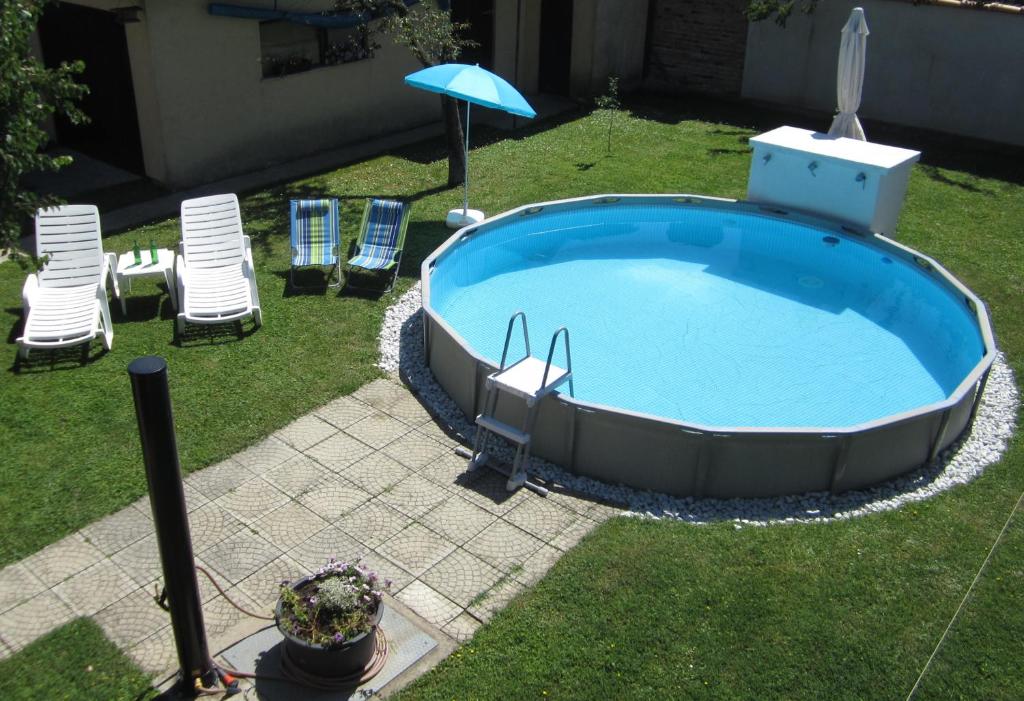 a large swimming pool with chairs and an umbrella at Apartman TIM in Osijek