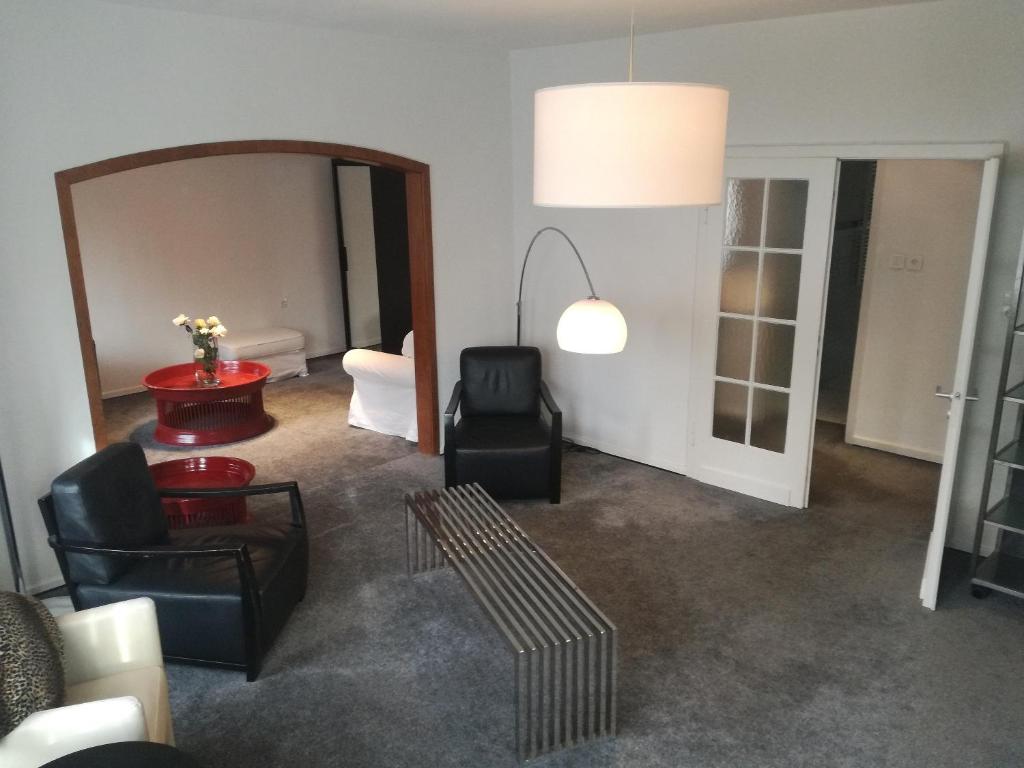 ein Wohnzimmer mit einem Tisch, Stühlen und einem Spiegel in der Unterkunft Top Ferienwohnung Krämer in Koblenz
