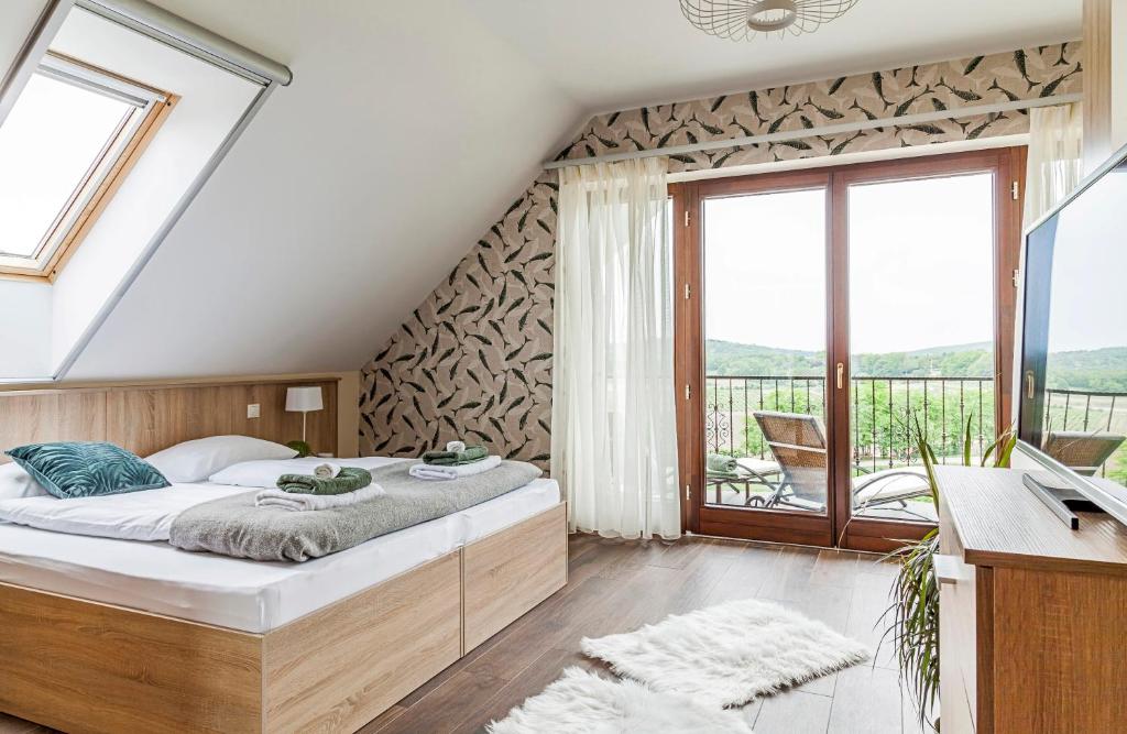 a bedroom with a bed and a balcony at Pilger Apartments in Tihany