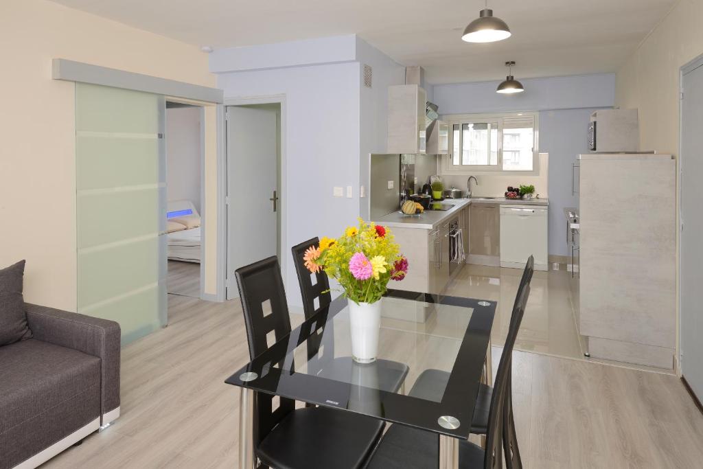 a living room with a glass table with a vase of flowers at Appartement 2 chambres Angers Centre de Congrès in Angers