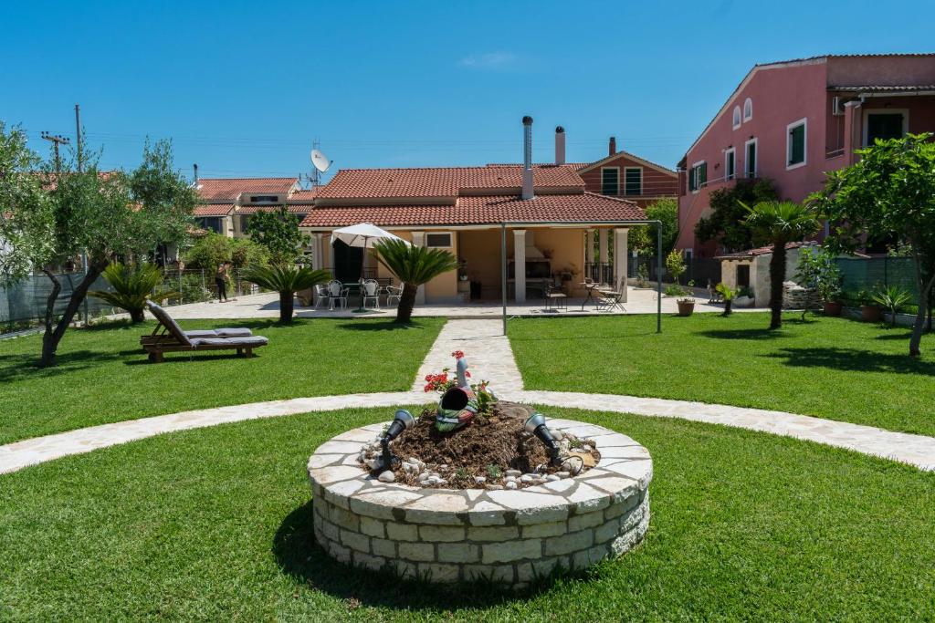 a garden with a fountain in the middle of a yard at La casa di Eleni in Acharavi
