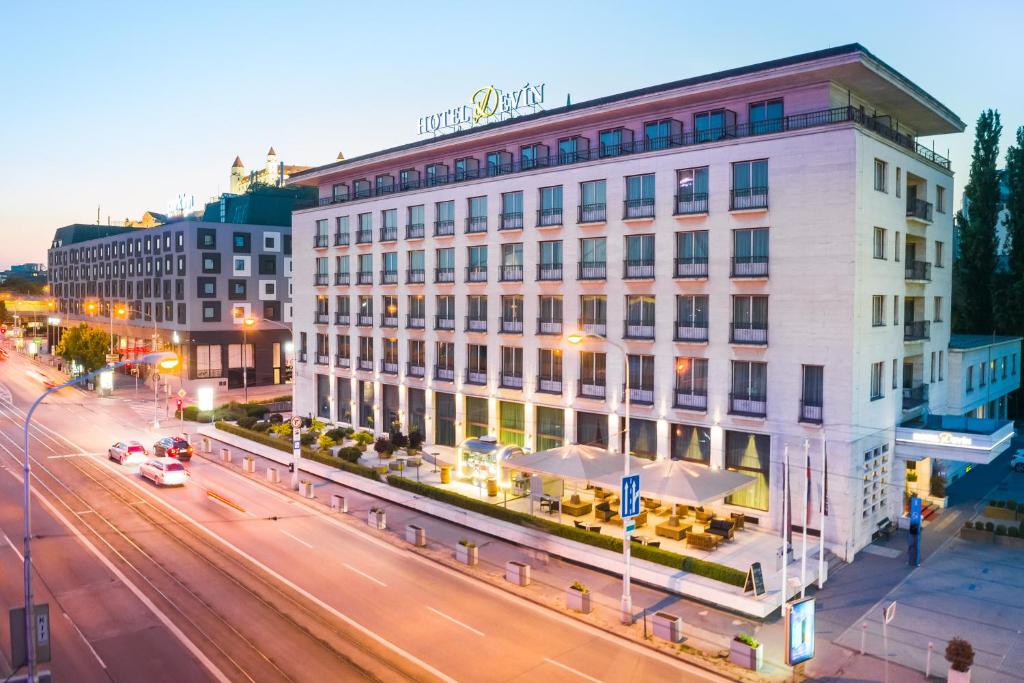 a large white building on a city street at night at Hotel Devín in Bratislava