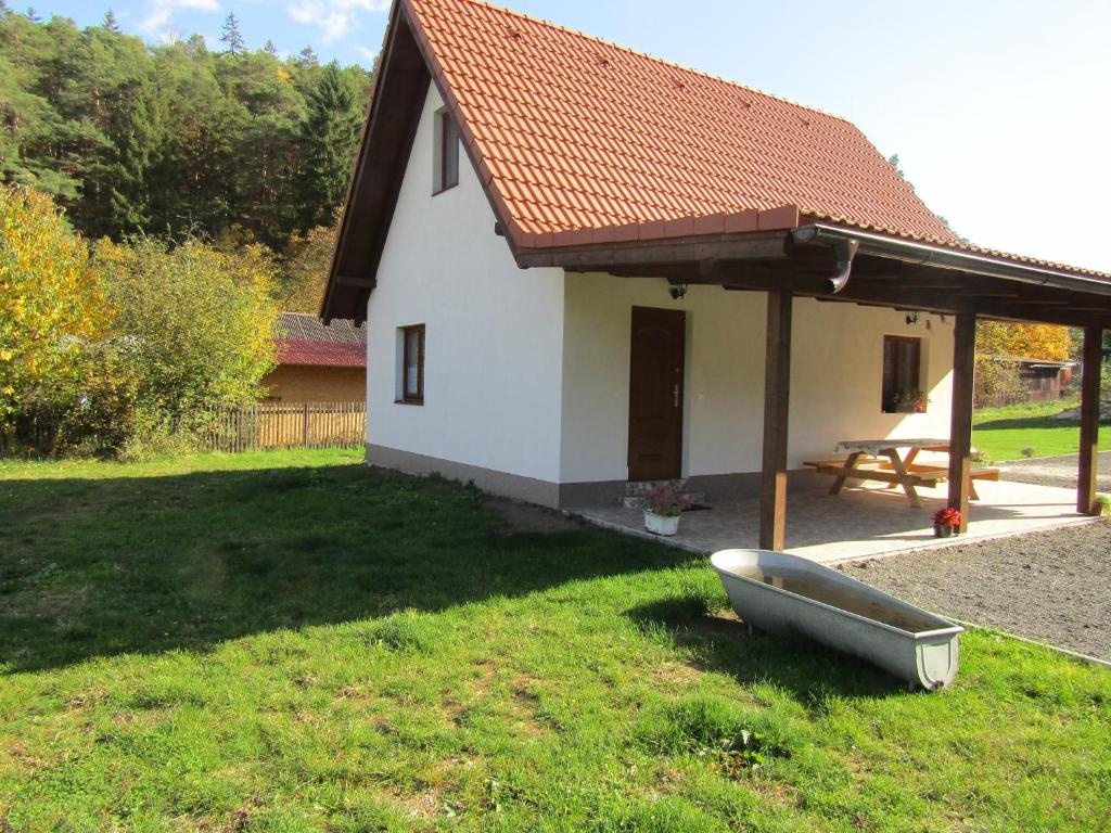 ein kleines weißes Haus mit einem Boot im Hof in der Unterkunft rekreační dům levandule in Jince
