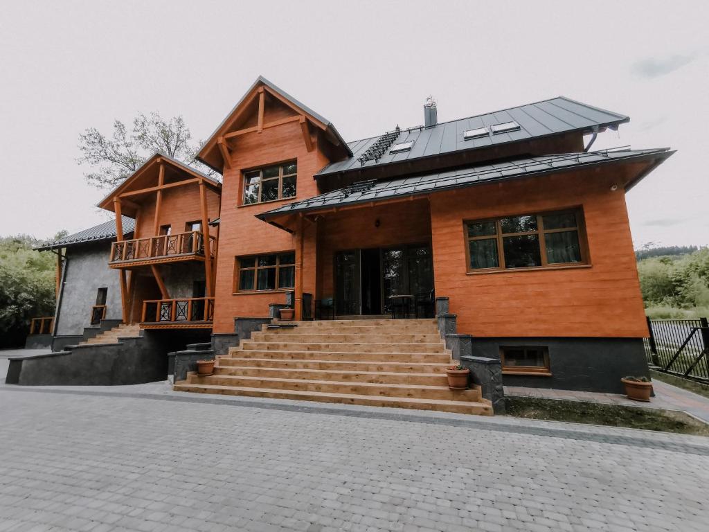 a wooden house with stairs in front of it at Wysokie Horyzonty in Karpacz