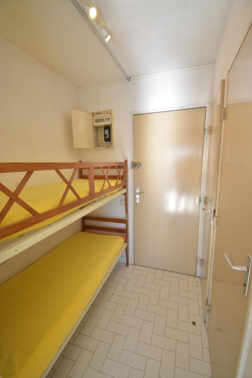 Cette chambre comprend 2 lits superposés et une porte. dans l&#39;établissement Studio cabine vue port grand pavois M, au Grau-du-Roi