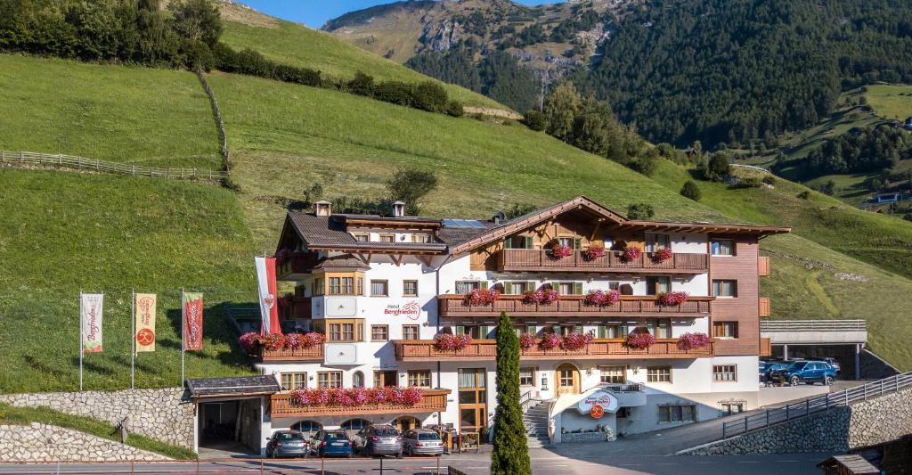 un hotel en las montañas con flores en los balcones en Hotel Bergfrieden, en Martello