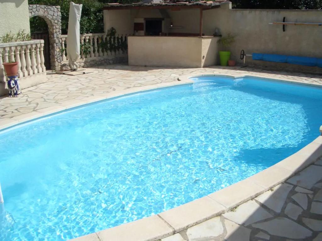 una piscina con acqua blu in un cortile di Villa avec jardin à Poussan avec piscine privée ouverte toute l'année a Poussan