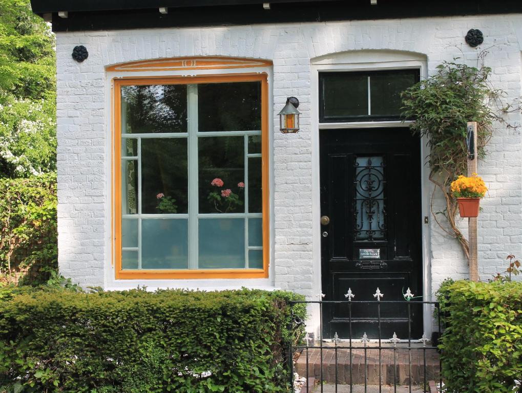 een zwarte deur met een raam op een wit huis bij B&B Appartement De Winkeljuffer in Bakkeveen