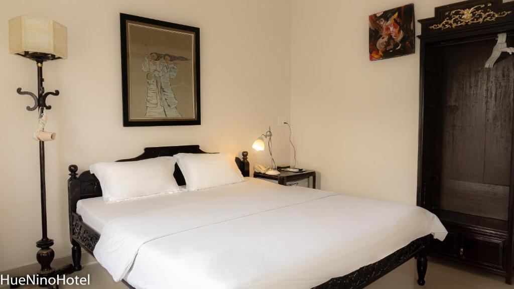 Postel nebo postele na pokoji v ubytování Hue Nino Hotel