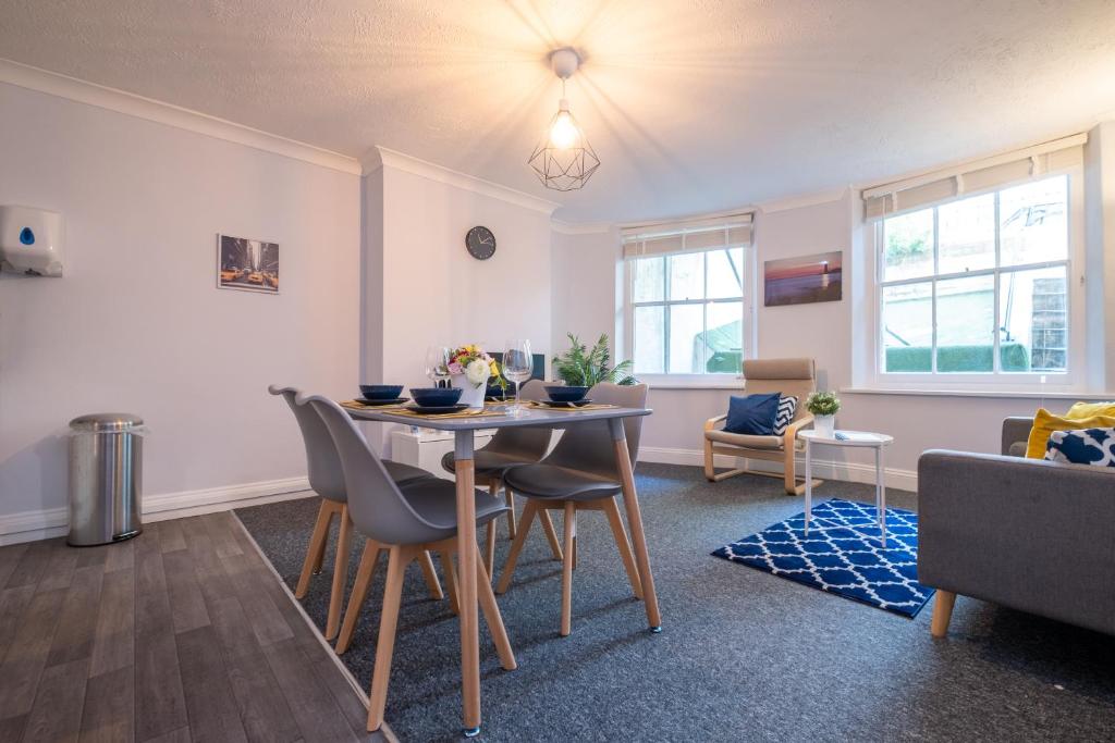 ein Wohnzimmer mit einem Tisch und Stühlen in der Unterkunft Brunswick in Brighton and Hove by 9S Living in Brighton & Hove