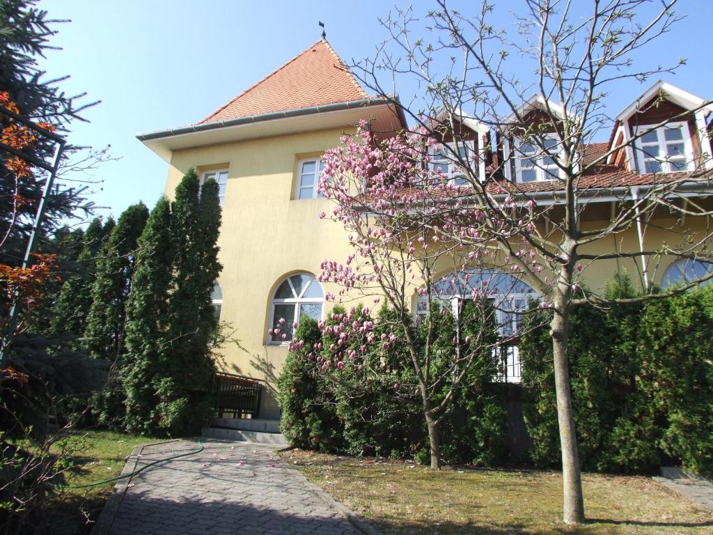 una casa con un árbol floreciente delante de ella en Art Guesthouse, en Budapest