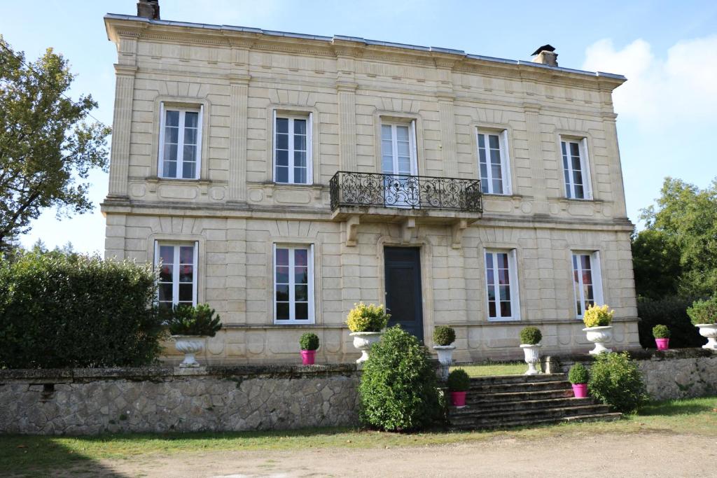 an old stone house with a balcony in front of it at Domaine de la Hure in Saint-Symphorien
