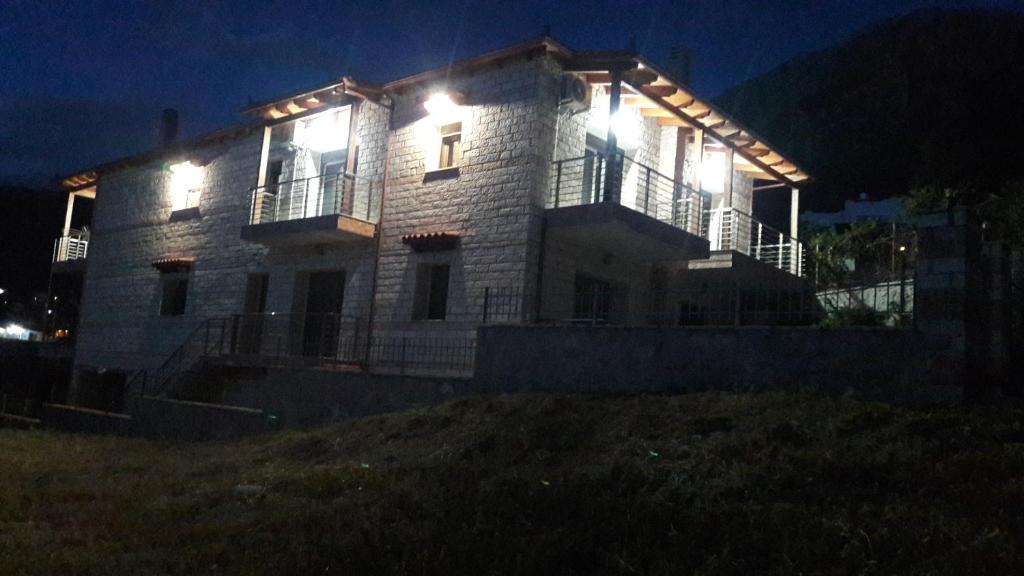 a large building with lights on it at night at Stone Villa at Alyki Beach in Alikí