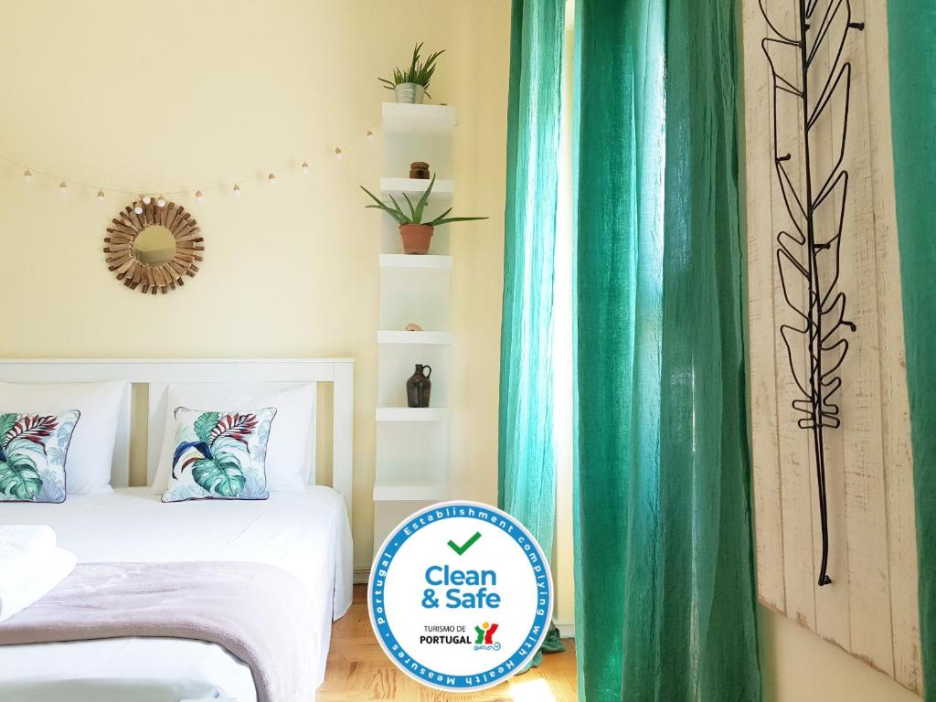 a bedroom with a bed and a green curtain at Green Element Guesthouse in Costa da Caparica