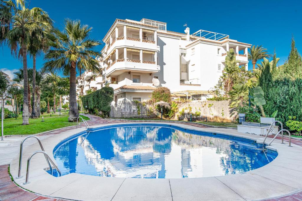 a villa with a swimming pool in front of a house at TIMON II, Luxury 3 bedroom Beachside Apartment in Benalmádena