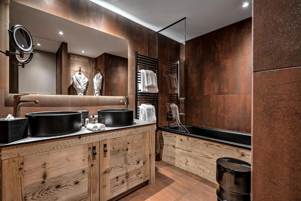 a bathroom with two sinks and a large mirror at Hôtel La Sivolière in Courchevel