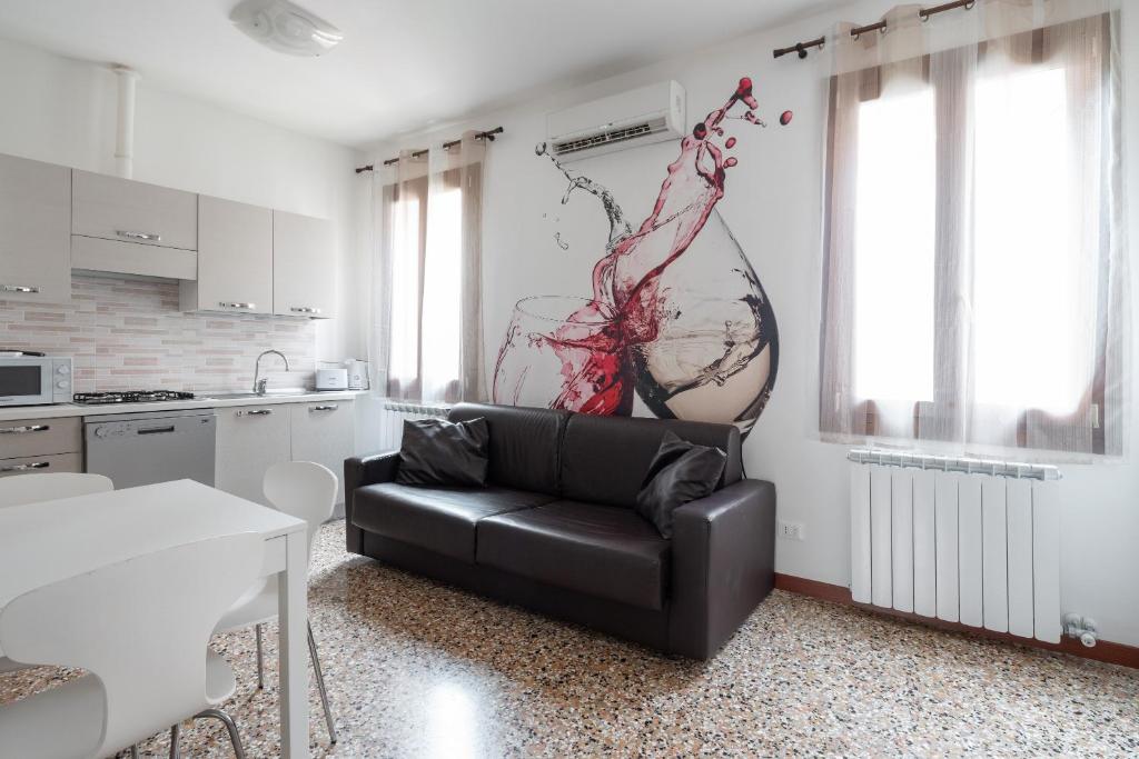 ヴェネツィアにあるSan Polo Canal View Apartments by Wonderful Italyのリビングルーム(黒いソファ付)、キッチン