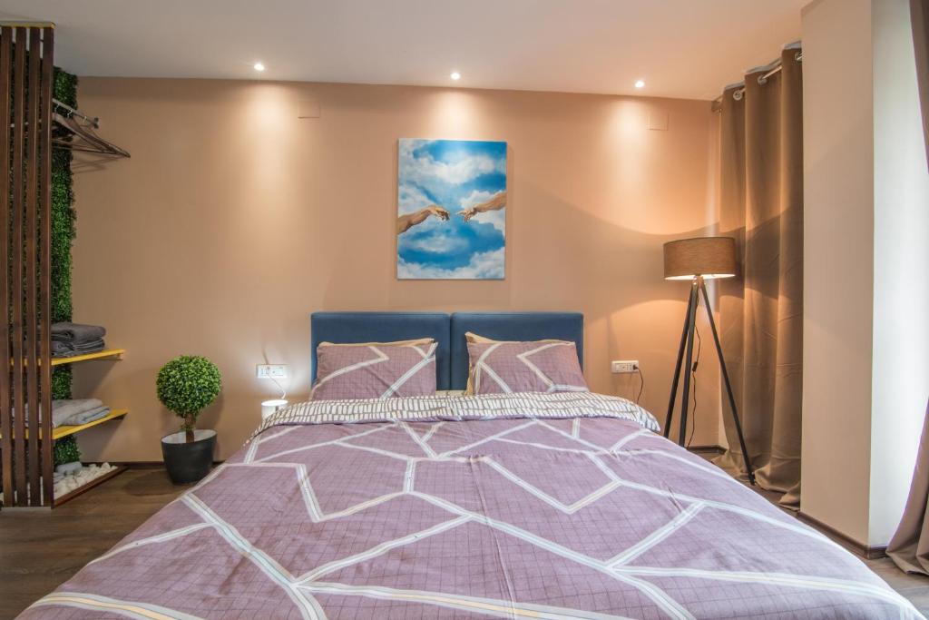 um quarto com uma cama com um edredão roxo em Vanilla Boutique Hotel em Skopje