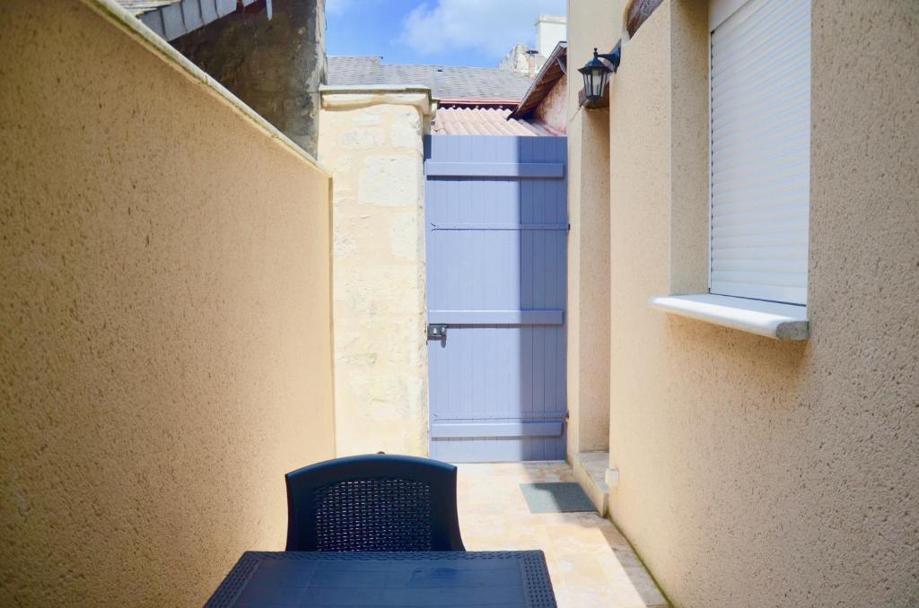 a blue chair sitting in an alley with a garage at Mon petit chez moi in Chinon