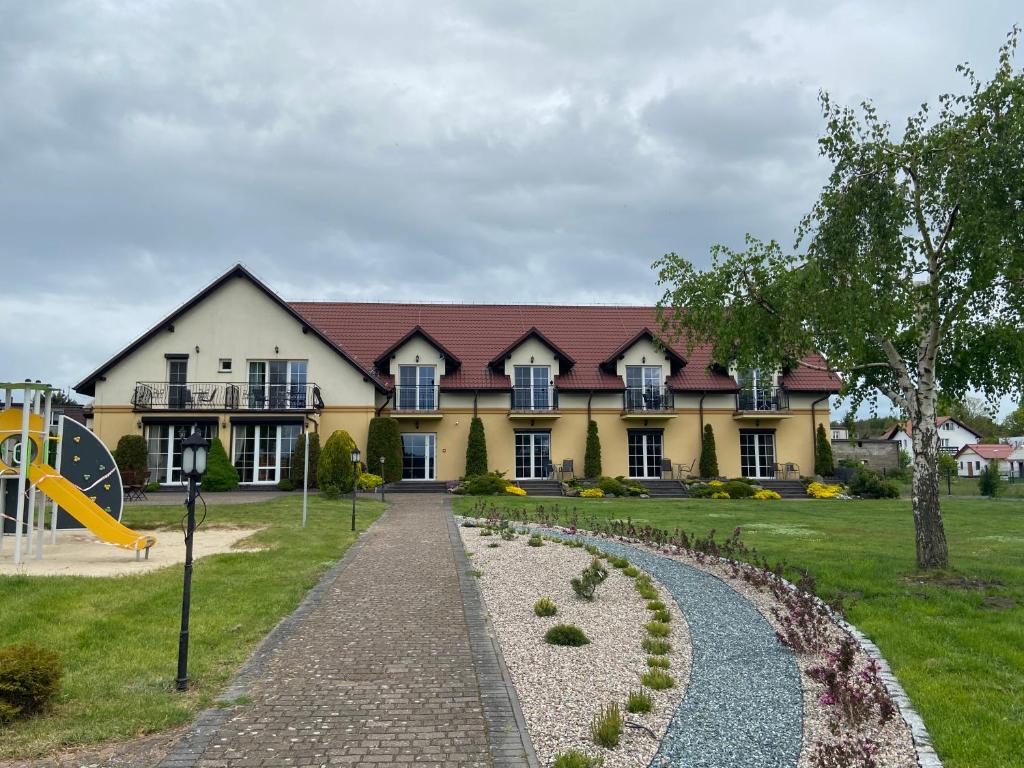 un gran edificio con un parque infantil delante de él en Paradise, en Charzykowy