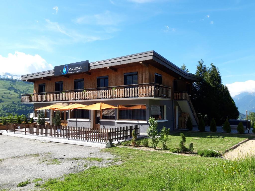 ein großes Holzgebäude mit einem Balkon in der Unterkunft Hôtel Spa L'Oxygène in Valmorel