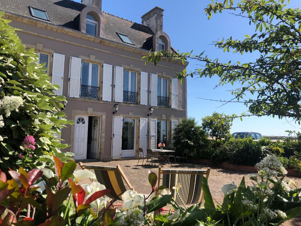 une maison avec des chaises devant elle dans l'établissement La Bourgeoise, à Portbail